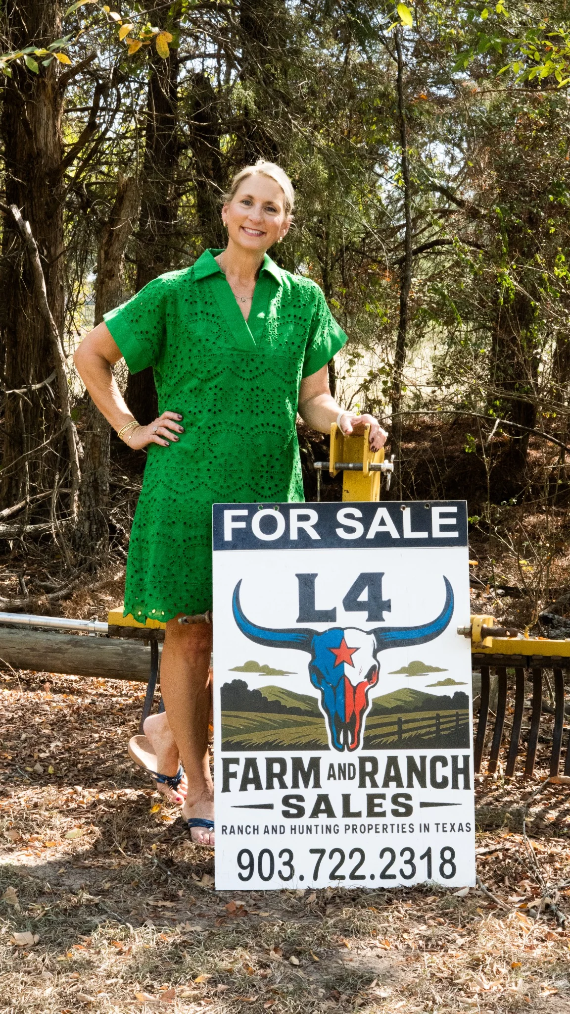 Sharon McDonald with an L4 Farm and Ranch for sale sign in East Texas
